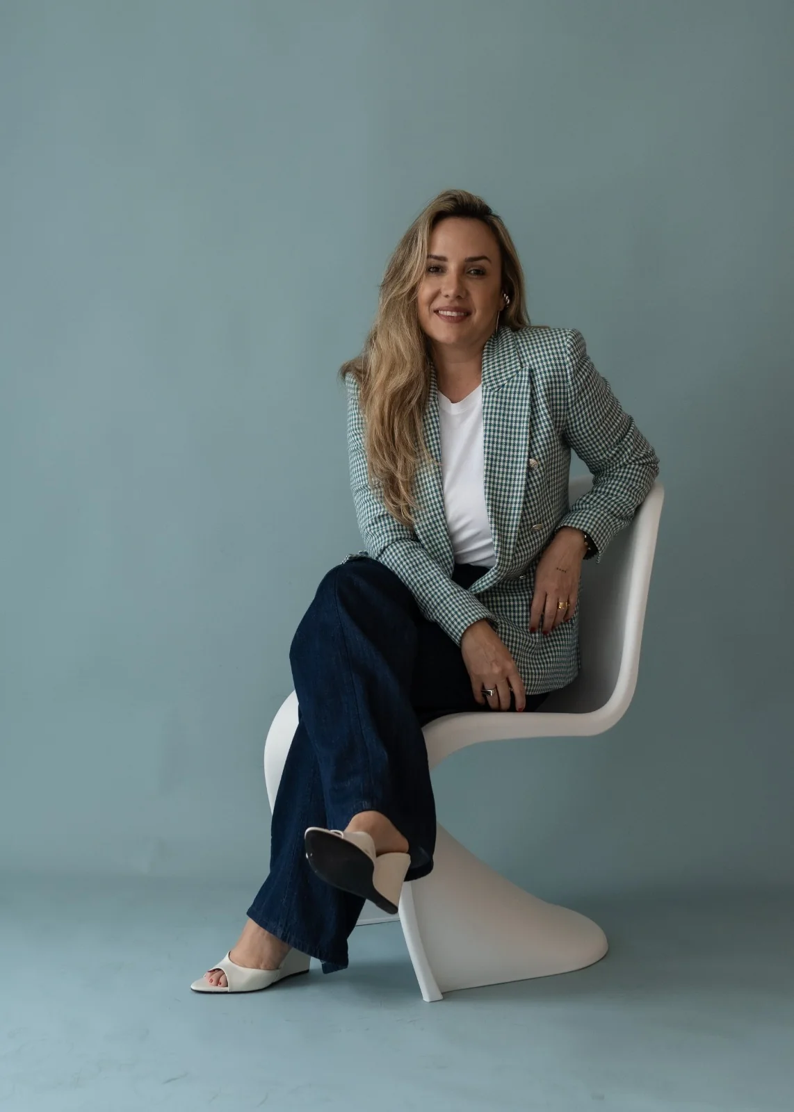 Débora Bolangno sentada em contexto profissional de liderança